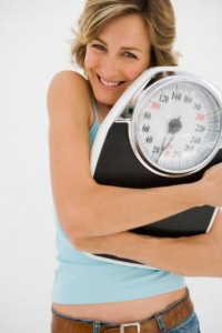 woman hugging a scale and smiling